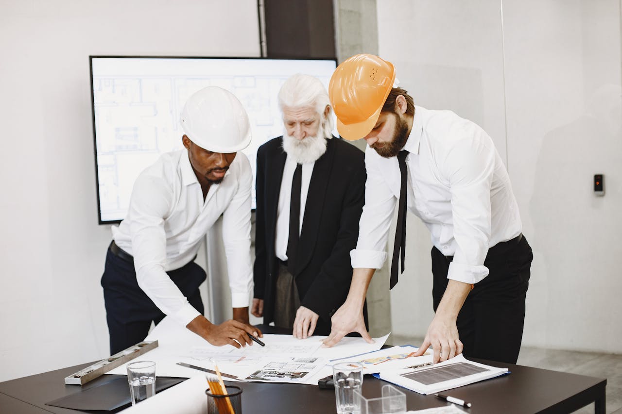 Engineers in a site meeting reviewing documents