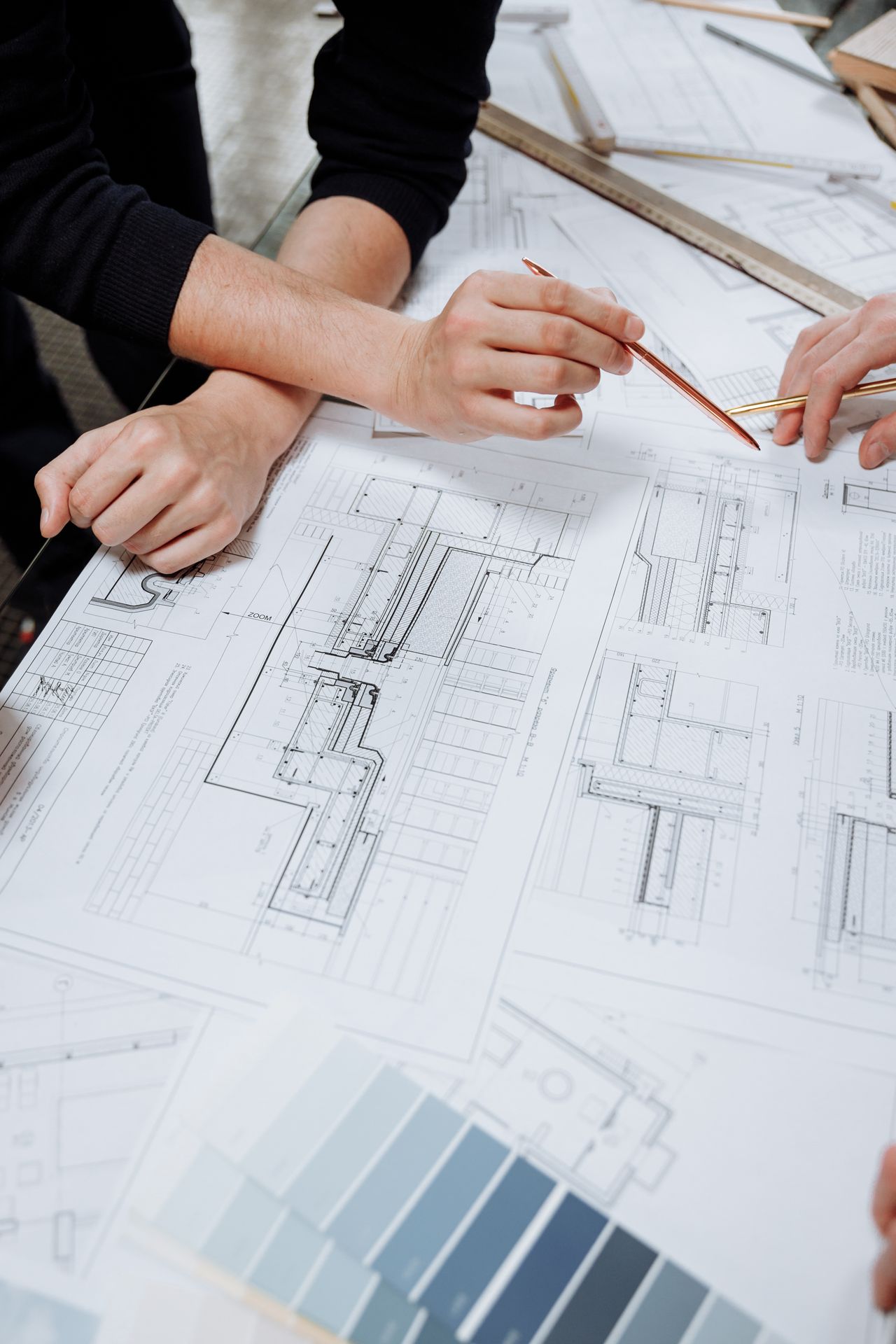 Hands inspecting construction drawings and documents